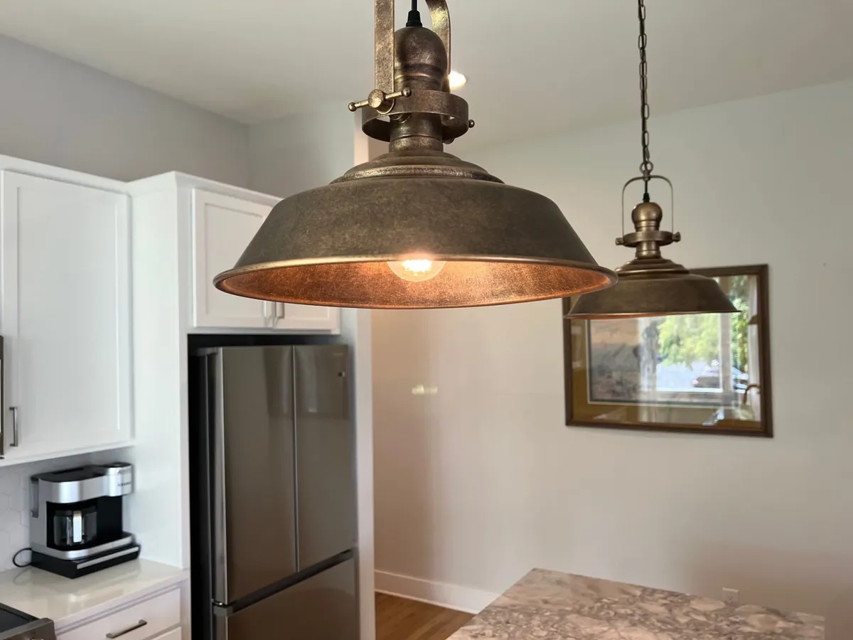 A modern, inviting kitchen interior featuring a kitchen island, sleek appliances, and stylish lighting. The space is set up for cooking, casual dining, and family gatherings.
